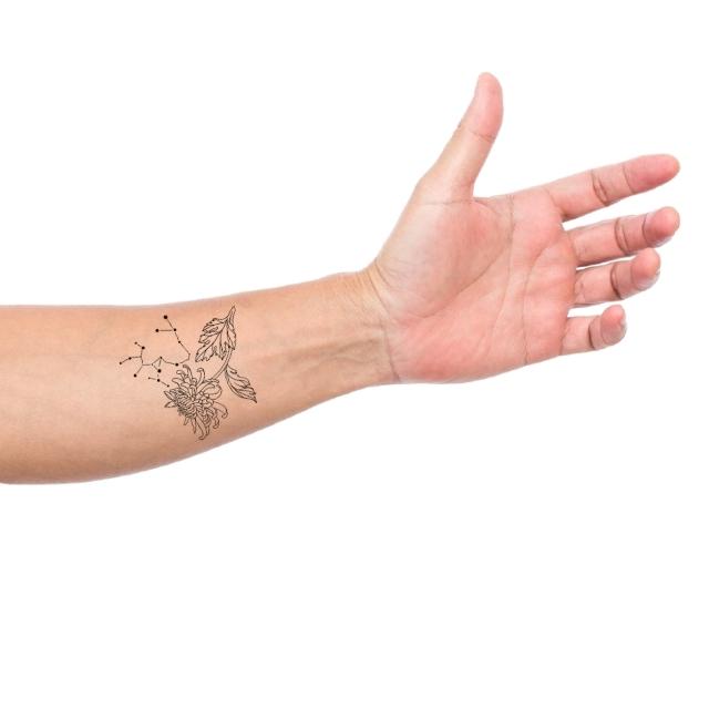 Sagittarius zodiacal sign tattoo on the left forearm.